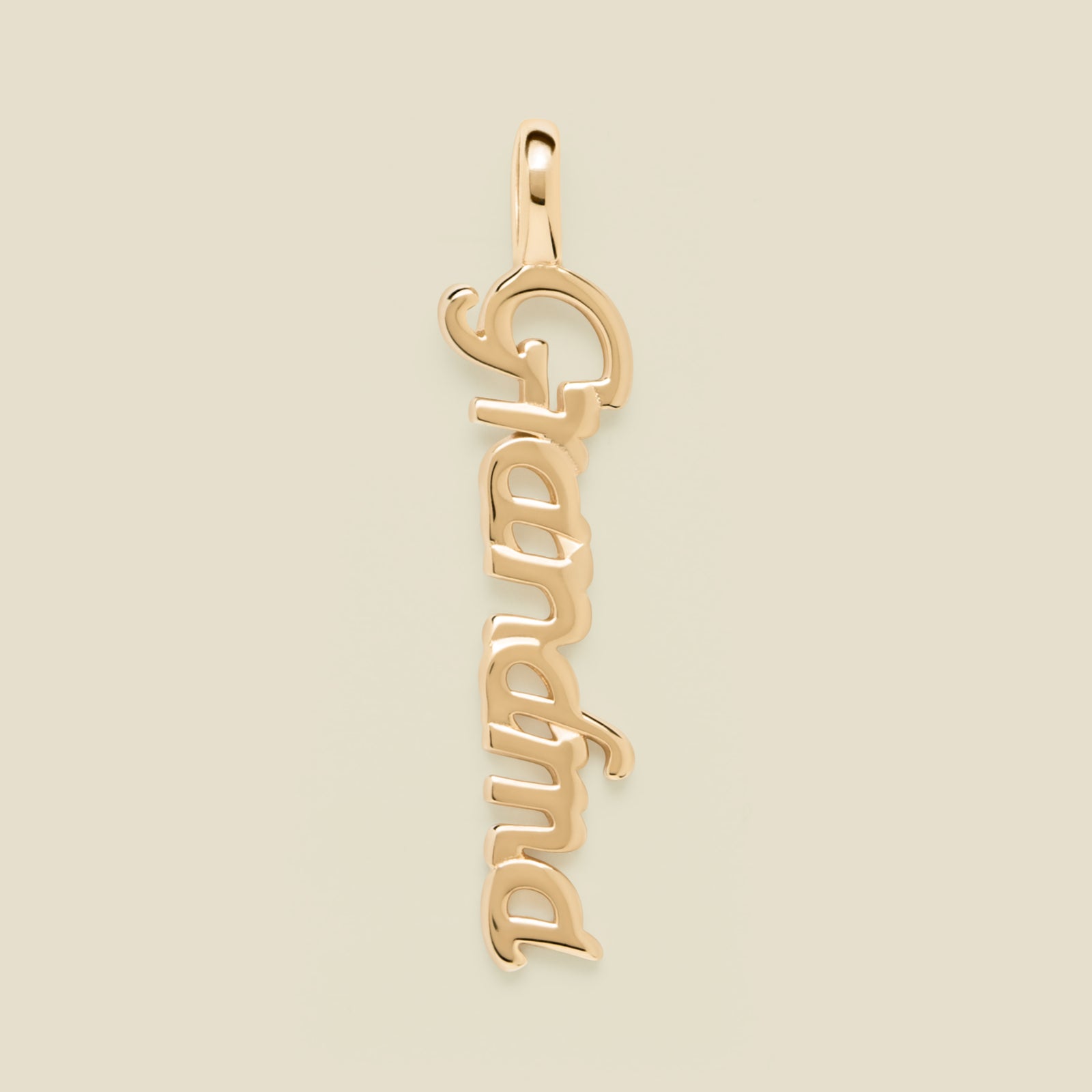 Gold 'Grandma' charm on a beige background
