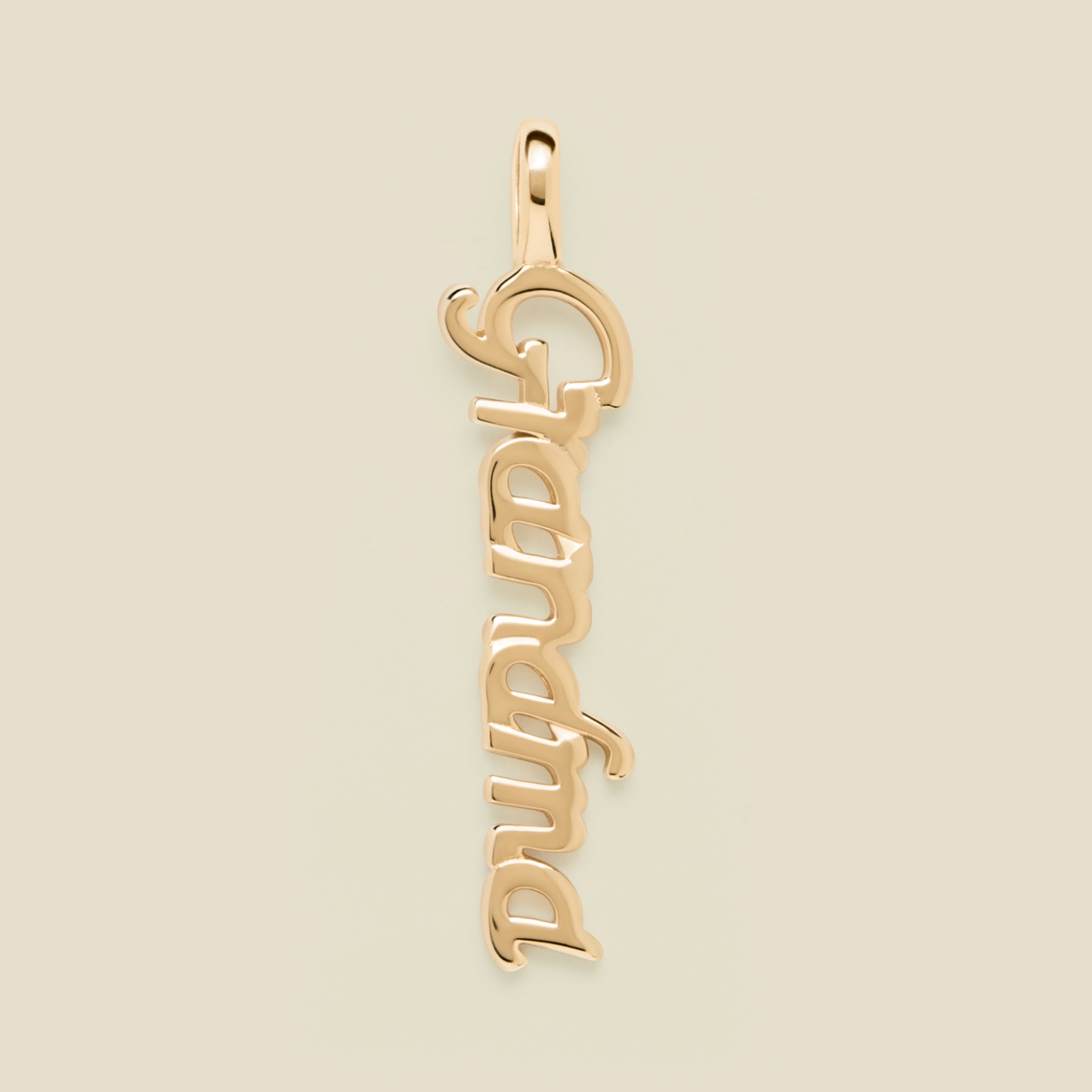Gold 'Grandma' charm on a beige background