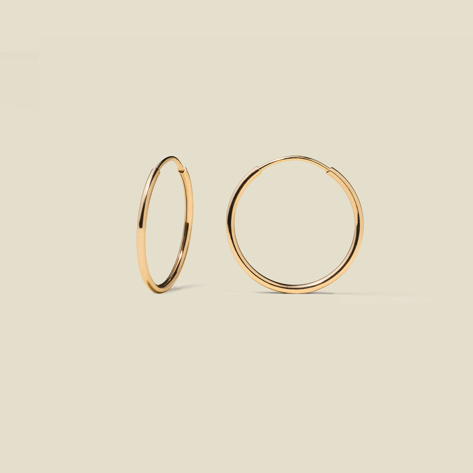 gold hoop earrings on a beige background