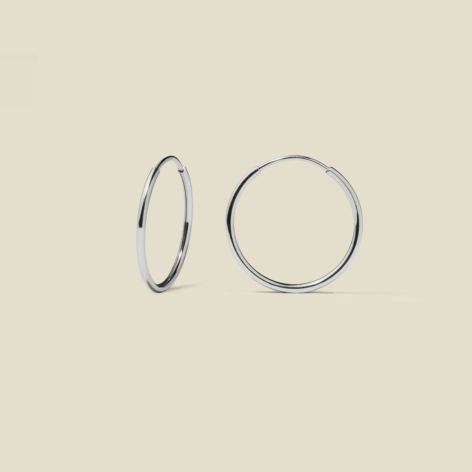 silver hoop earrings on a beige background