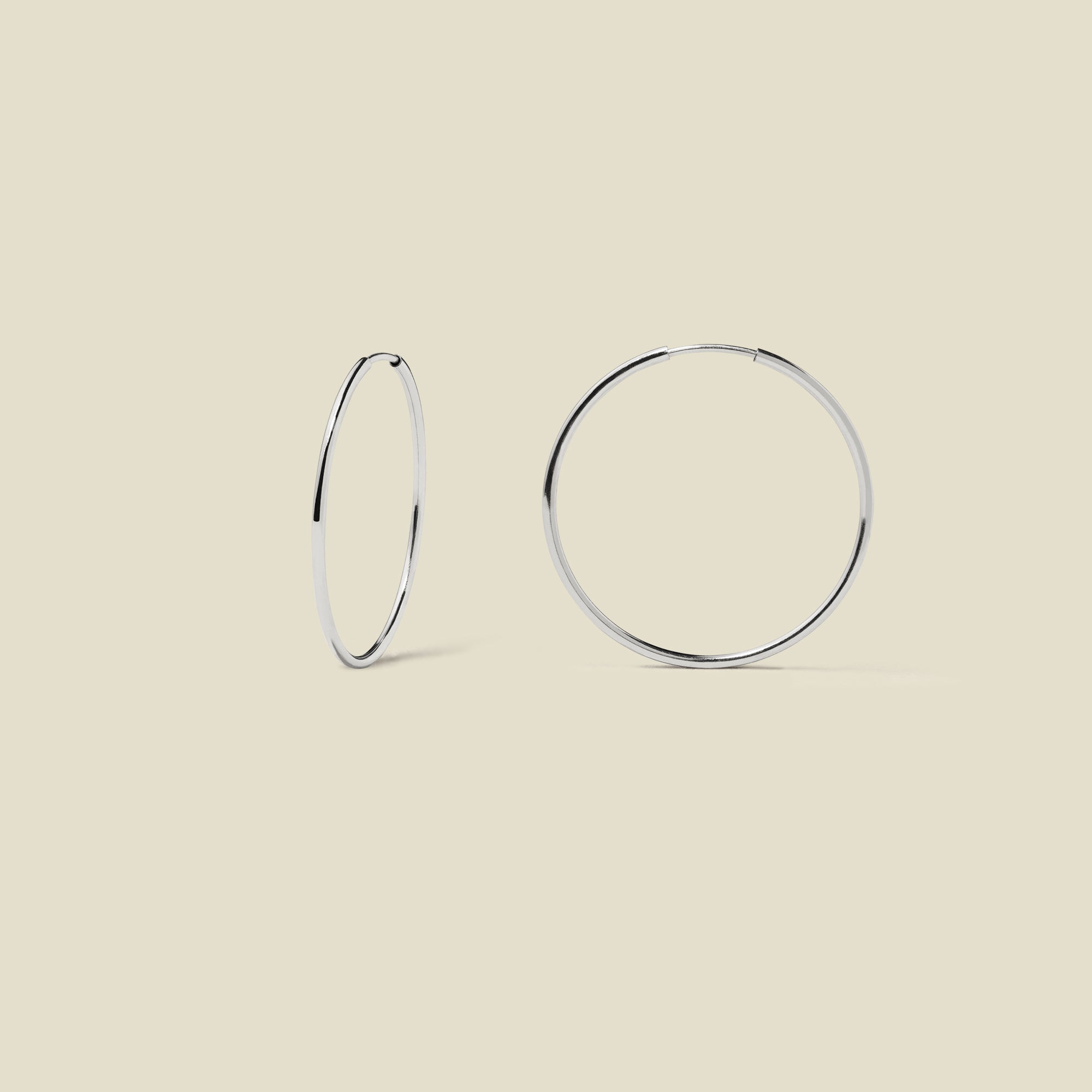 silver hoop earrings on a beige background