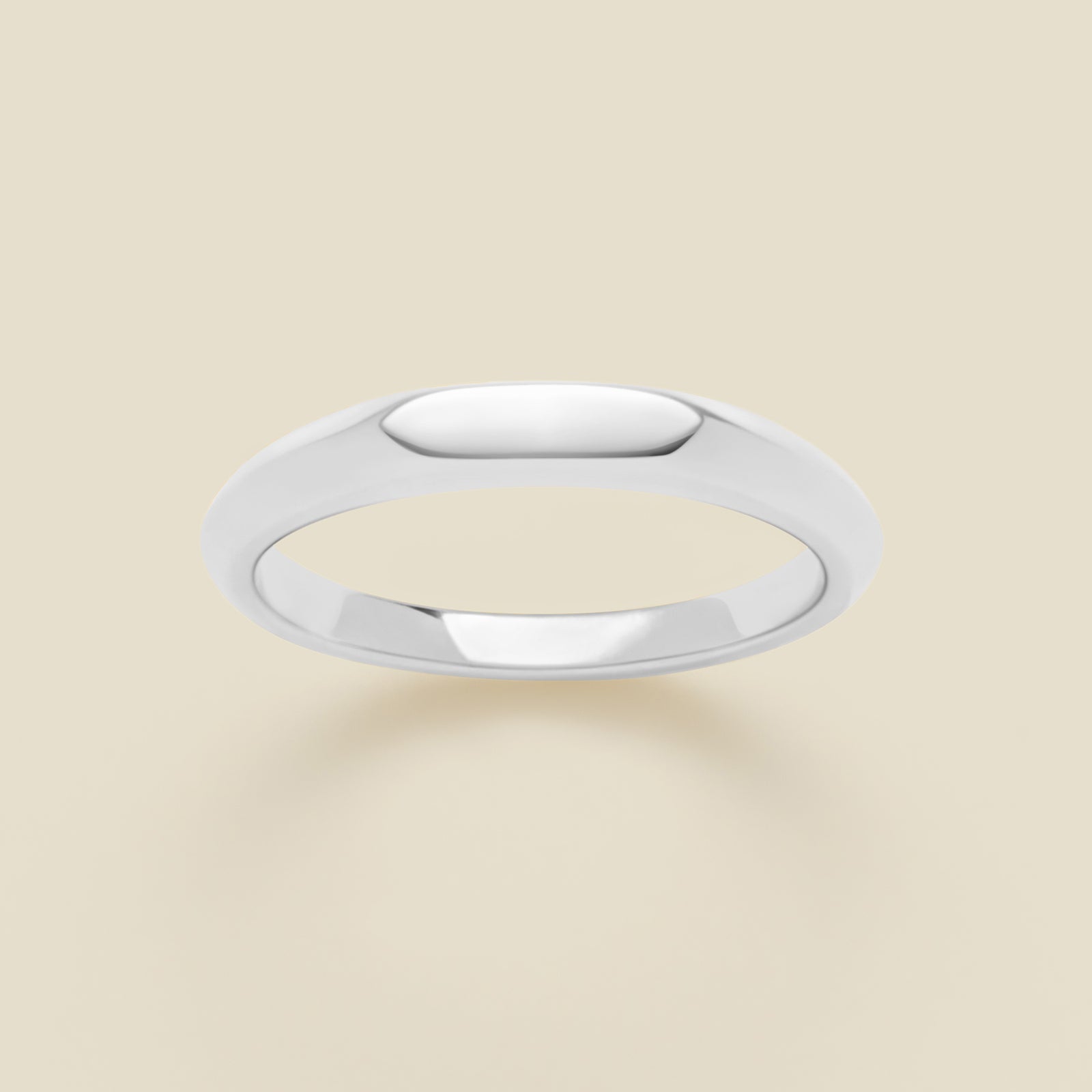 Silver signet ring on a beige background